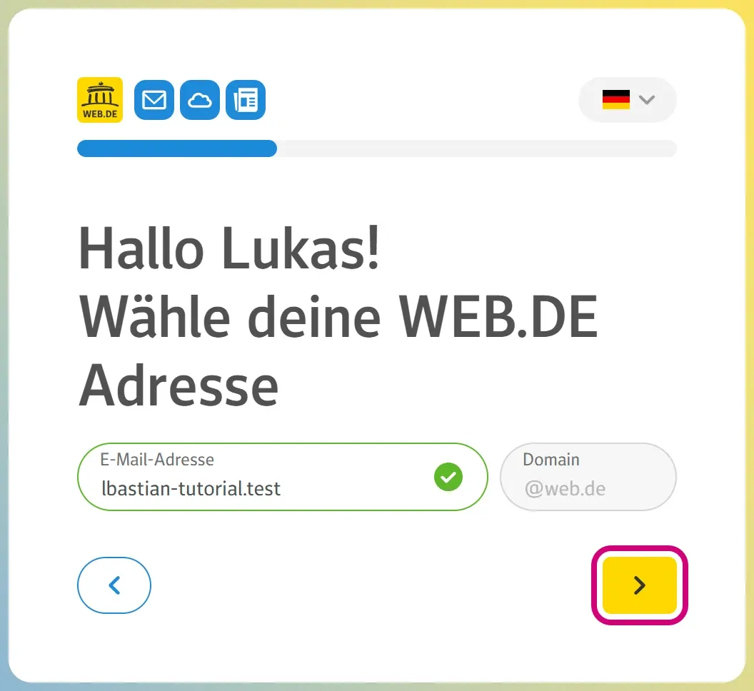 Die Seite „Wähle deine WEB.DE Adresse“ mit der Wunschadresse und einem grünen Haken. Der gelbe Pfeil-Knopf unten rechts ist markiert.